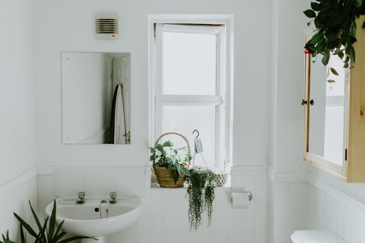 Contemporary bathroom with warm stone surfaces and matte brass tapware